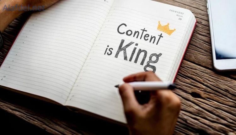 يد إنسان تمسك قلم وأمامها دفتر مكتوب فيه content is king وذلك ضمن وظائف Copywriter