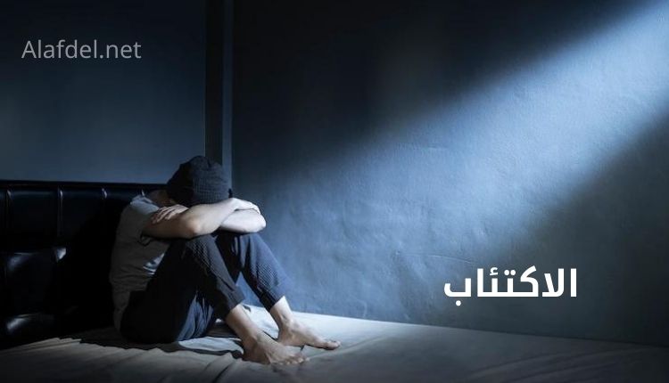 صورة بها شخص يجلس في غرفته على السرير يضع رأسه على يديه ويعاني من الاكتئاب depression