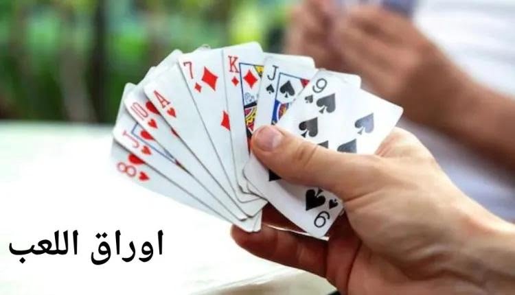 صورة فيها لاعبين، تظهر يد لاعب فيها أوراق اللعب Playing cards