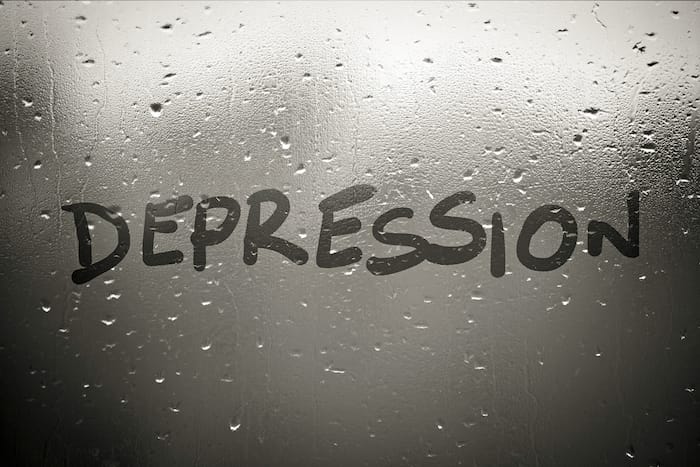 صورة بها كلمة الاكتئاب depression مكتوبة عليها وخلفها يوجد خلفية رصاصي اللون عليها نقاط تشبه نقاط المطر وذلك عند الحديث عن ما هو الاكتئاب