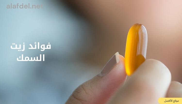 صورة بها يد تمسك حبة صفراء ومكتوب على الصورة فوائد زيت السمك benefits of fish oil