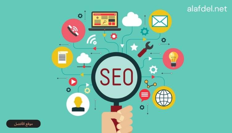 صورة بها يد تمسك عدسة بها كلمة seo وحولها رموز وعلامات ضمن الحديث عن تحسين محركات البحث (SEO)