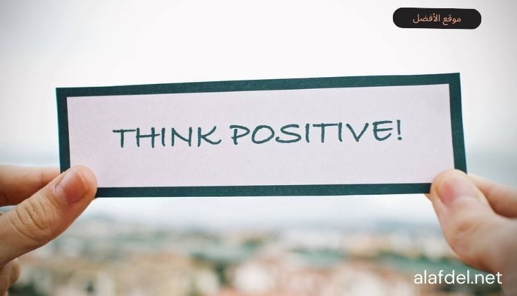 صورة بها يد تمسك لافتة مكتوب عليها فكر بإيجابية think positively ضمن الحديث عن أهم طرق علاج القلق