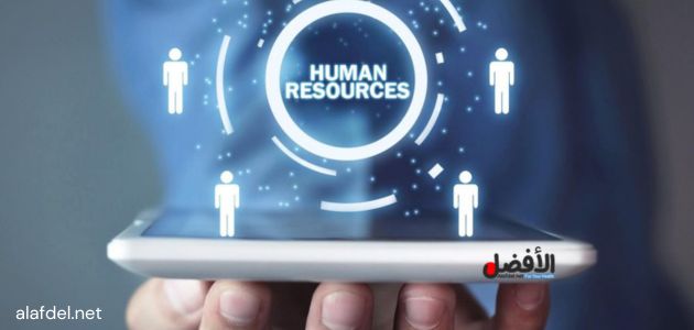 صورة بها يد شخص تمسك جهاز ذكي فوقه رموز وأشكال وكلمة human resources في دائرة ضمن الحديث عن تكنولوجيا المعلومات وأثرها على الموارد البشرية