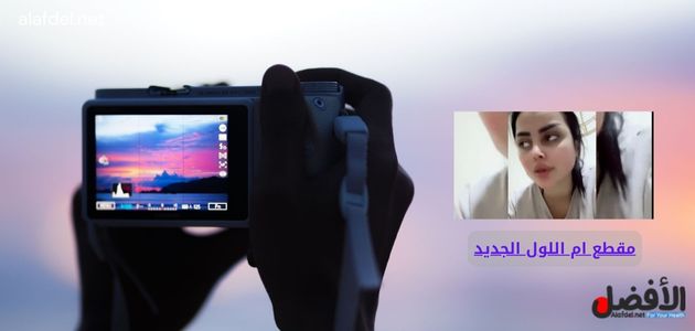 صورة بها يد تمسك كاميرا تصوير مع صورة الراقصة العراقية ام اللول ضمن الحديث عن مشاهدة فيديو ام اللول كامل