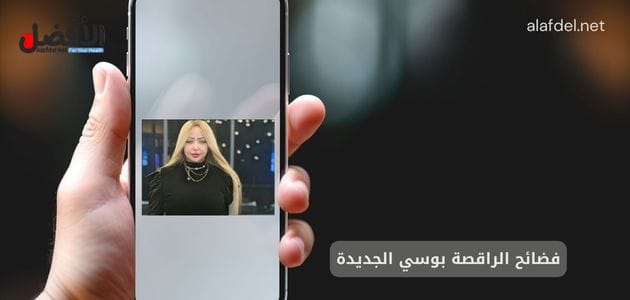 صورة بها يد تمسك هاتف موجود عليه صورة الراقصة المصرية بوسي ضمن الحديث عن فضائح الراقصة بوسي الجديدة