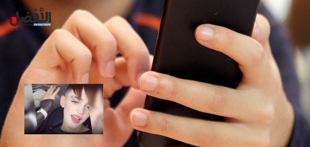 فيديو فيه جزء من شخص يمسك هاتف في يديه مع صورة المغربي ادم بنشقرون ضمن الحديث عن سكس ادم بنشقرون 