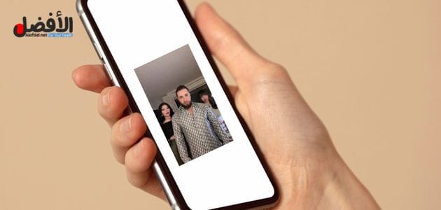 صورة بها يد تمسك هاتف عليه صورة انطونيو سليمان مع فتاتين ضمن الحديث عن سكس ساشا بيرل مع انطونيو سليمان