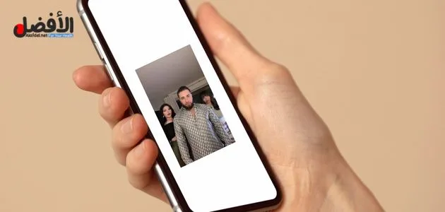 صورة بها يد تمسك هاتف عليه صورة انطونيو سليمان مع فتاتين ضمن الحديث عن سكس ساشا بيرل مع انطونيو سليمان سكس